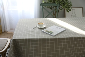 Close-up of light green plaid linen tablecloth with white check pattern on a rectangle table