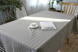 Close-up of grey plaid linen tablecloth showing fine weave and modern grid texture