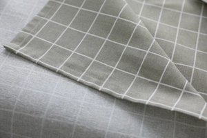 Detailed close-up showing the precise stitching and texture of the green linen checkered tablecloth