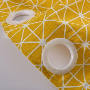 Macro view of modern yellow geometric cotton linen curtains with white metal grommets