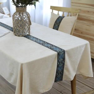 Detail van het beige fluwelen tafelkleed met blauw etnisch patroon en zachte textuur