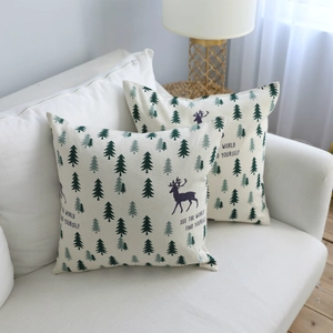 Nordic cotton linen pillow cover with forest pine and reindeer on a white sofa
