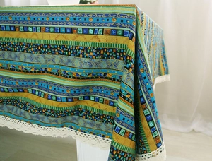 Close-up of bohemian striped table cloth with white lace trim and geometric prints