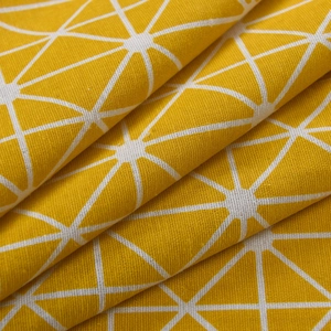 Detail of yellow cotton linen fabric with white geometric star patterns and thick texture
