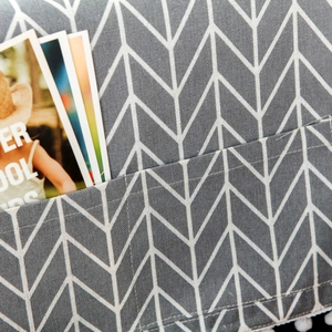 Close-up of grey linen microwave cover with white arrow patterns and storage pocket