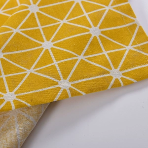 Detail shot of yellow cotton linen curtain fabric with white geometric triangle patterns