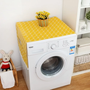 Yellow geometric washing machine cover with white pom-poms and side storage pockets
