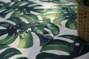 Detail von wasserdichtem Monstera-Druckstoff mit Wassertropfen auf der Oberfläche