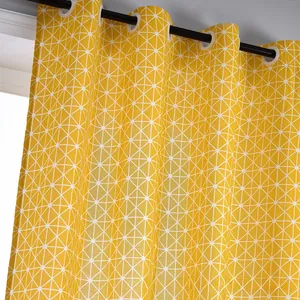 Detail of yellow cotton linen curtain with white geometric triangle patterns and metal eyelets