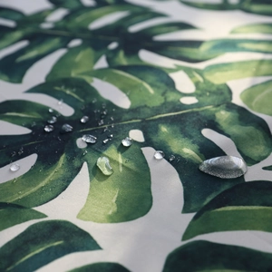 Nappe monstera verte imperméable avec gouttelettes d'eau sur le tissu textile