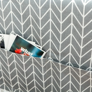 Detail of grey geometric dust cover with herringbone pattern and side storage pocket