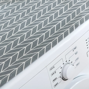 Detail view of gray geometric herringbone dust cover on top of white washing machine