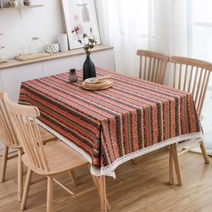 Bohemian linen cotton tablecloth with colorful stripes and white lace edges on wood table
