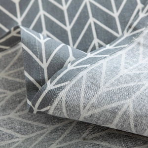 Close-up of gray geometric leaf pattern dust cover with detailed stitching and linen texture