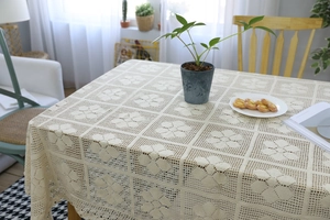 Macro view of beige crochet lace tablecloth with intricate floral openwork patterns