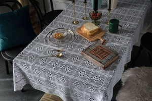 Detailed macro view of white crochet lace tablecloth with hollow geometric patterns