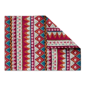 Close-up detail of Bohemian style woven fabric with geometric patterns and red orange tones
