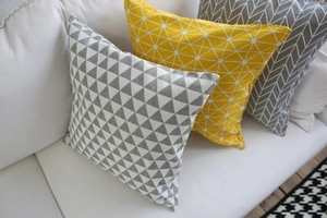 Dettaglio delle federe per cuscini geometrici grigi e gialli con texture del tessuto