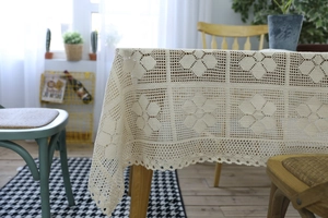 Detailed macro view of beige handmade crochet lace tablecloth with floral patterns