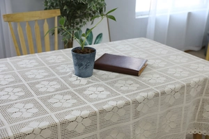 Close-up of vintage handmade crochet tablecloth with floral pattern and lace edge