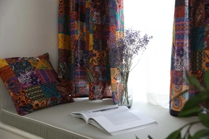 Dettaglio di tende e cuscini bohémien in lino con motivi paisley colorati