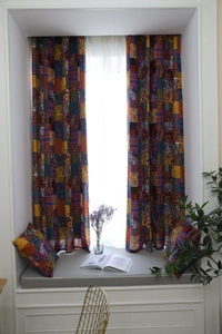 Dettaglio della tenda patchwork bohémien con motivi geometrici e trama in cotone e lino naturale