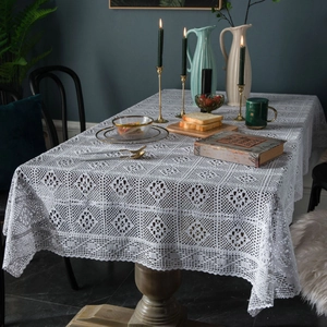 Vintage white crochet tablecloth with geometric floral patterns on a dark wood dining table