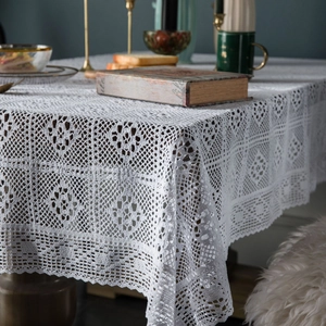 White crochet lace tablecloth with geometric patterns in a rustic vintage setting