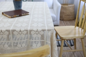 Close-up of vintage handmade crochet floral tablecloth with intricate hollow lace patterns