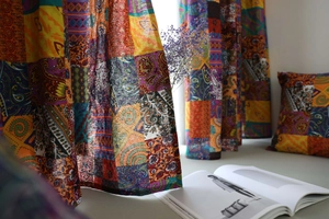 Dettaglio di tende patchwork boho con motivi paisley e trama spessa in cotone e lino
