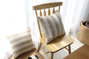 Detail of light brown and cream striped cotton linen pillow cover in a minimalist room