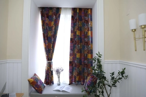 Dettagli dei motivi patchwork bohémien su tende in cotone lino e cuscino abbinato
