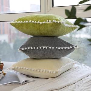Nordic style velvet pillows with pom-poms in green, grey and yellow for sofa decor