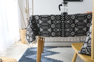 Vista dettagliata della tovaglia geometrica bianca e nera con nappe in cotone bianco