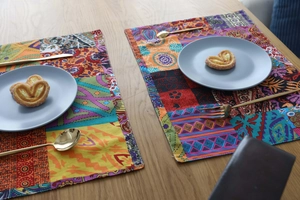 Detailed view of Bohemian cotton linen placemat with colorful patterns on a wooden table