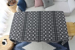 Dettaglio della tovaglia in lino bohémien geometrico con nappe bianche decorative