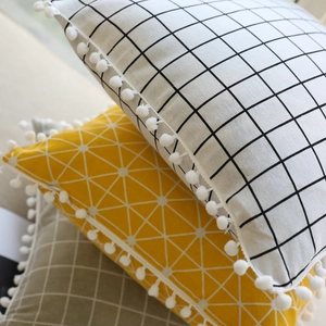 Nordic style geometric linen pillow covers with white pom-pom trim in a stacked layout