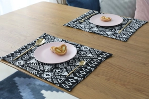 Detail of bohemian geometric placemat set on a wooden table with home decor accents