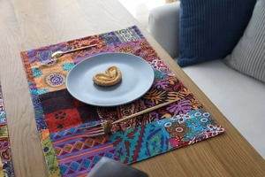 Detail of Bohemian patchwork placemat with floral patterns on a wooden dining table