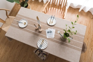 Detailed embroidery and fringe on rectangular linen-style tablecloth in gray and brown
