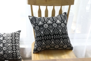 Detailed view of black and white geometric tribal patterns on a textured linen cushion cover