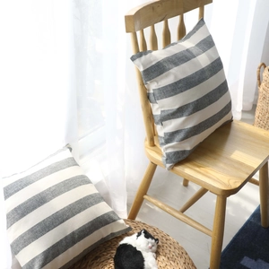 Grey and cream striped lumbar pillow cover in a cozy Scandinavian style home setting