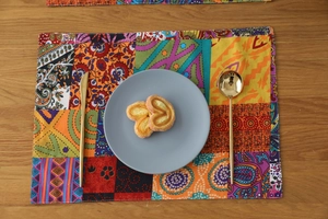 Top view of bohemian patchwork placemat with floral patterns on a wooden table