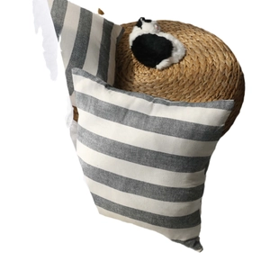 Set of two grey and white striped cushion covers on a round woven straw seat stool