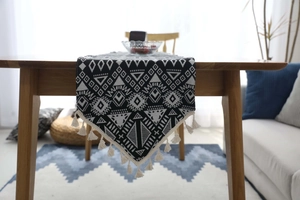 Detail of Nordic geometric table runner with cotton fringes and woven tribal pattern