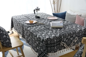 Detail of bohemian geometric cushion and tablecloth with ivory tassel fringe texture