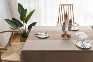 Detail of linen-textured tablecloth with brown block pattern and white lace edge