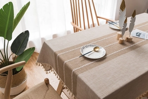 Close-up of linen table cloth with lace patchwork and handmade fringe tassels
