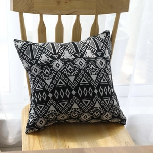 Ethnic black and white geometric cushion on wooden chair with natural light