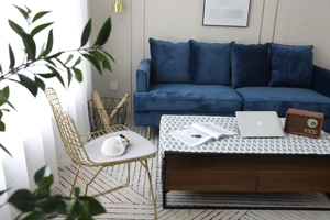 Détail de nappe nordique en coton et lin avec motif feuilles vertes sur table en noyer